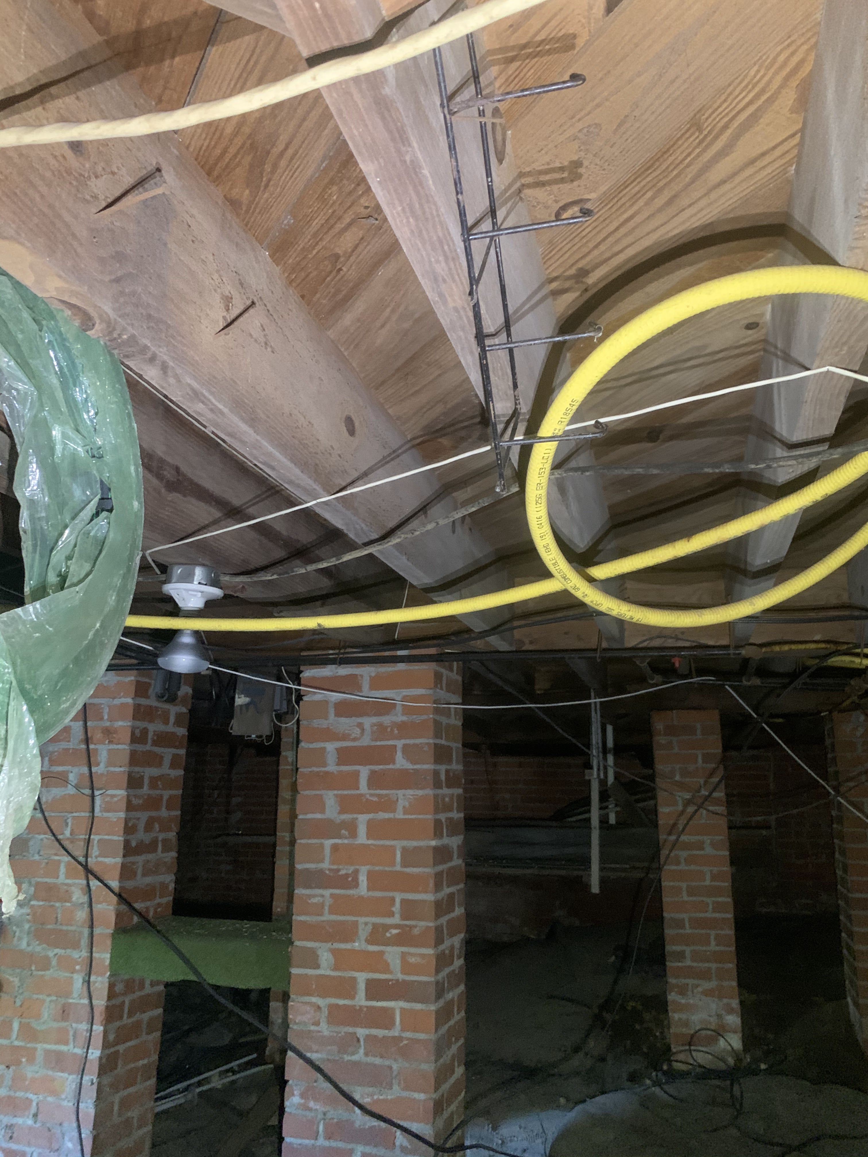 Crawlspace before encapsulation — exposed joists and dirt floor