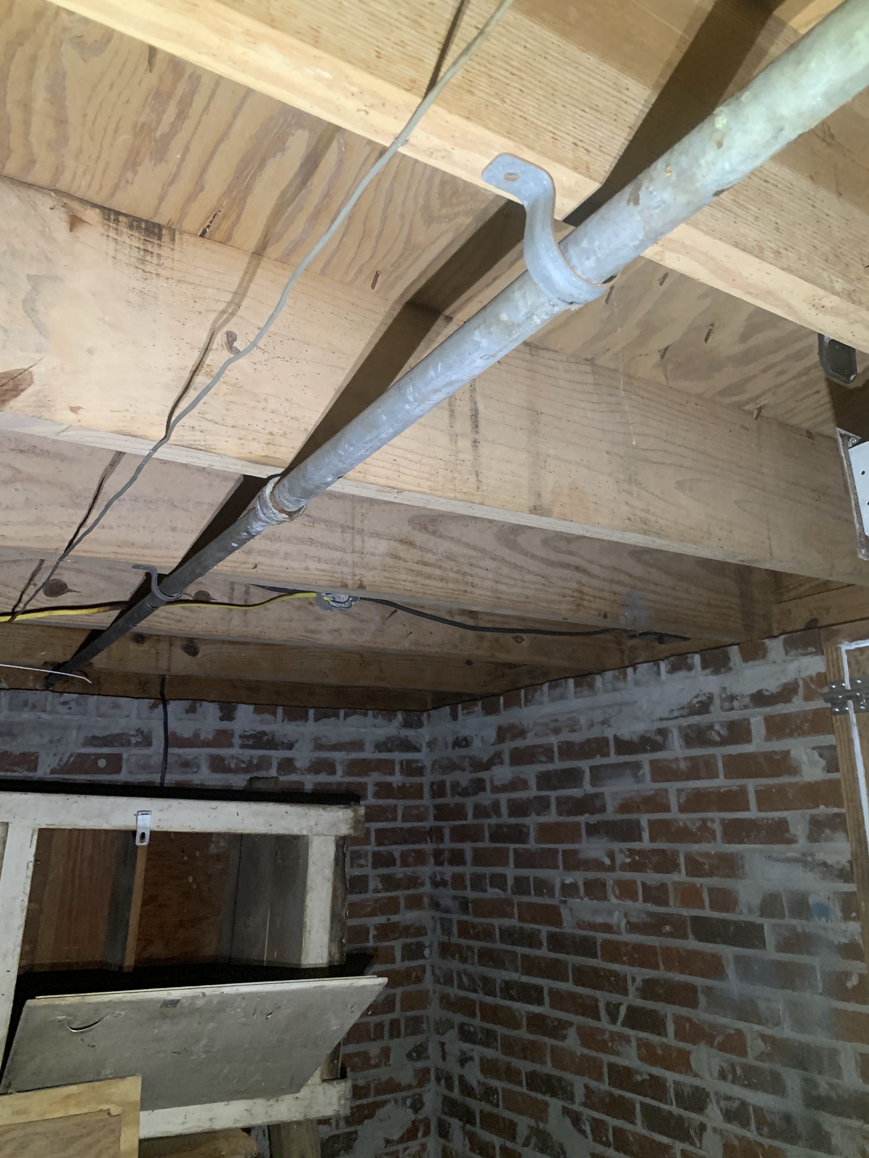Crawlspace before encapsulation — moisture and debris visible
